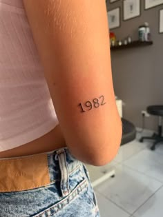 a woman with a small tattoo on her arm that reads,'929 '