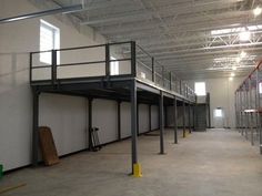 an empty warehouse with metal railings and balconies on the second floor is seen in this image