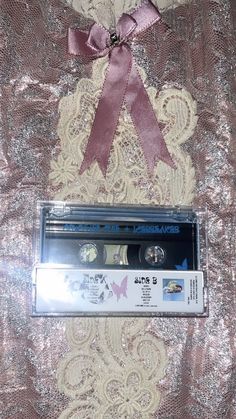 a pink ribbon on top of an old cassette player