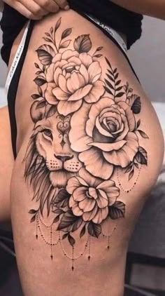 a woman's thigh with roses and a lion on it