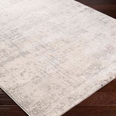 a white rug on top of a wooden floor with dark wood floors in the background