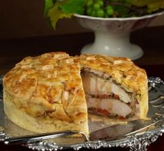 a meat and vegetable pie on a silver platter