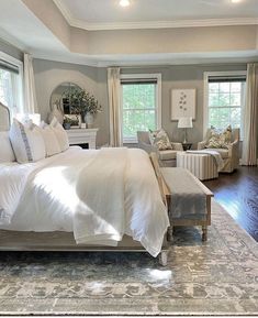 a large bed sitting inside of a bedroom on top of a hard wood flooring