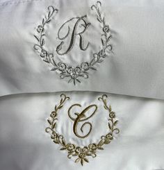 an embroidered monogram on the back of a white jacket with gold trimmings