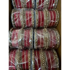 several red and white bangles are wrapped in plastic wrap on top of each other