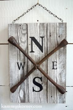 a wooden sign with two baseball bats hanging from it's sides and the word n is