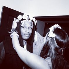 a woman with flowers in her hair standing next to another woman