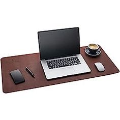 a laptop computer sitting on top of a desk next to a cup of coffee