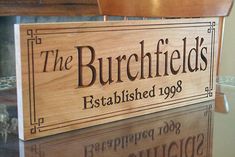 a wooden sign that says the burchfields established in 1908 and is on top of a glass table