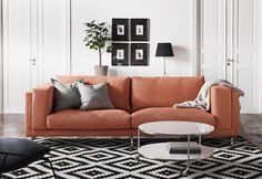 a living room with orange couches and black and white rugs on the floor