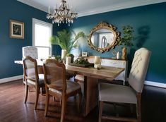 a dining room with blue walls and wooden floors