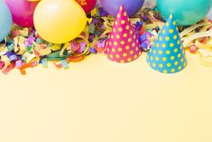 colorful party hats and streamers with confetti on yellow background