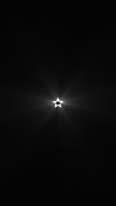 a black and white photo of a star in the dark