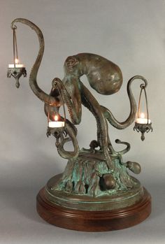 an octopus sculpture with two candles in it's tentacles