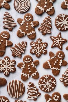 gingerbread cookies with white icing are on a sheet of parchment paper and the words, gingerbread cookies easy vegan