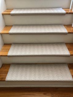 a set of stairs with carpeted treads and wooden handrails in a home