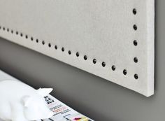 a white pig figurine sitting on top of a magazine next to a wall