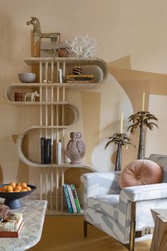 a living room filled with furniture and bookshelves next to a wall mounted shelf