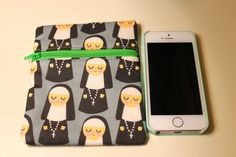 a cell phone sitting on top of a bag next to a wallet with nun's