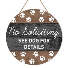 a wooden sign that says no solicing see dog for details with paw prints on it