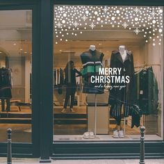 a store front window with mannequins dressed in christmas sweaters