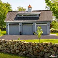 a house with two garages and a stone wall