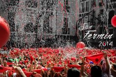 a large group of people with red balloons and confetti