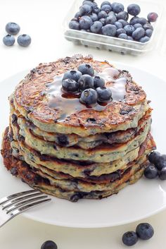 a stack of pancakes with blueberries and syrup on top