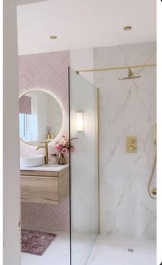 a bathroom with a walk in shower next to a white sink and mirror on the wall