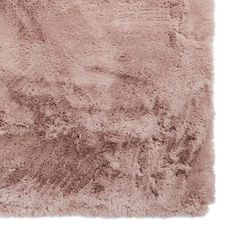 a pink rug with shaggy fur on the bottom and one corner is shown in full view