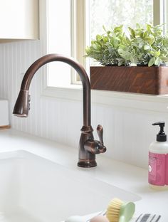 a kitchen sink with a faucet and soap dispenser