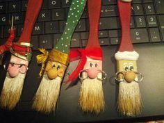 four gnome heads are attached to the keys of a computer keyboard, with one keychain in the shape of an elf's head