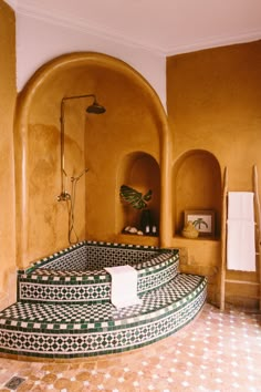 a bathroom with tiled flooring and walls in the shape of steps leading up to a bathtub