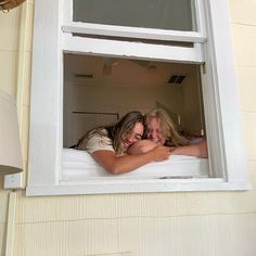 two women are cuddling in the window sill