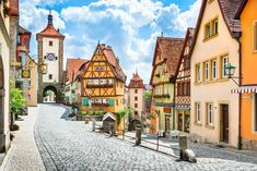 a cobblestone street in an old european town with half timber buildings on both sides