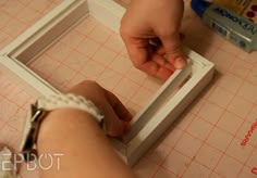 a person is making something with scissors on a cutting board that has been cut into squares