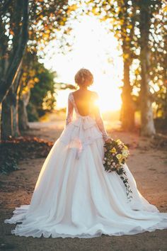 a woman in a wedding dress is walking down the road