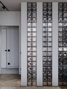 the wall is made up of metal circles and glass panels, along with an area rug in front of it