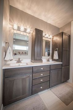 a bathroom with two sinks, mirrors and lights on the wall above them is shown