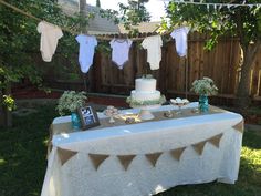 a table that has some cake on it with bunting and baby's breath