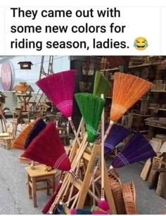 several different colored brooms sitting on top of each other