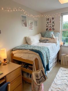 a bed room with a neatly made bed next to a window and a rug on the floor