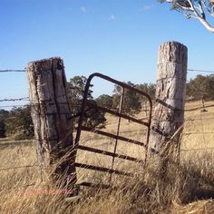 an old rusted gate in the middle of a field