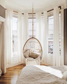 a bedroom with a hanging chair in the corner