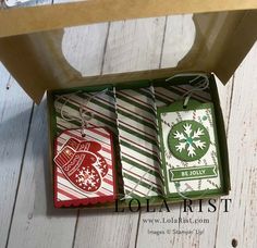 two christmas gift tags in a box on a table