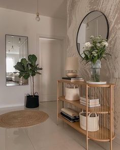 a living room filled with furniture and a plant on top of a wooden shelf next to a mirror