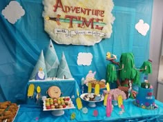 an adventure time birthday party with desserts and snacks on a table in front of a blue backdrop