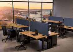 an empty office with desks and chairs in front of a large window overlooking the city