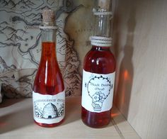 two bottles of liquid sitting on top of a counter next to each other in front of a map