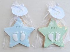 two decorated cookies in the shape of stars with footprints and name written on each one